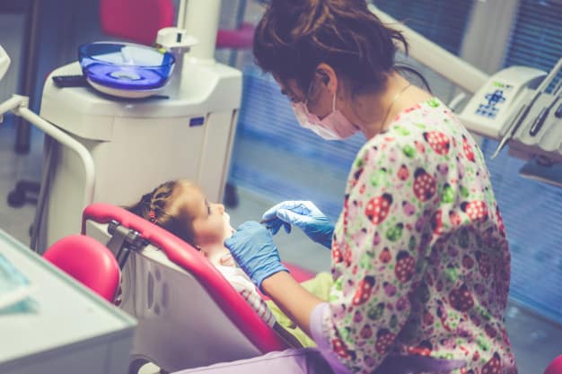 A child receiving restorative dental care, such as a filling, at our clinic in Aluva.