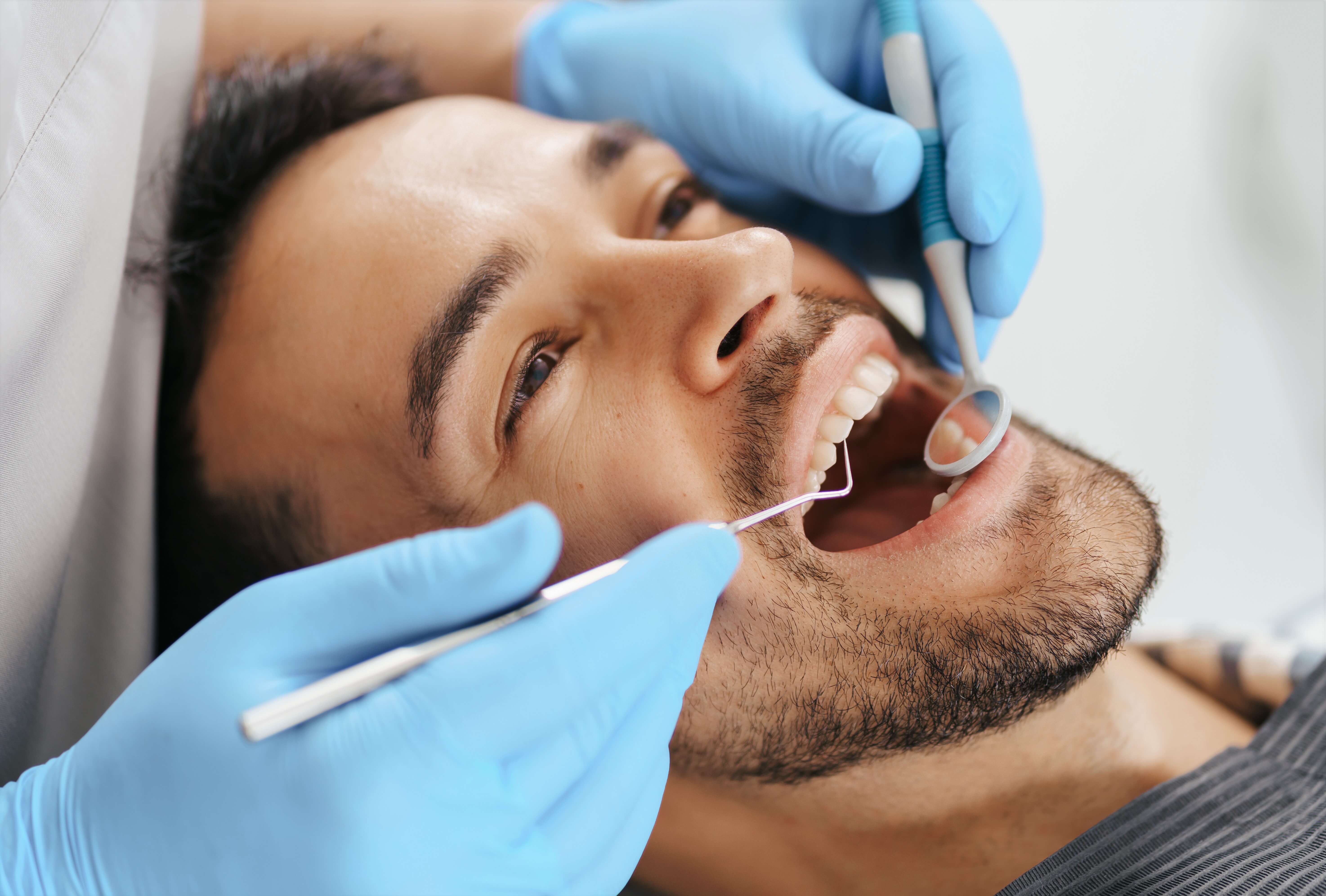 A dental professional performing gum surgery on a patient's mouth